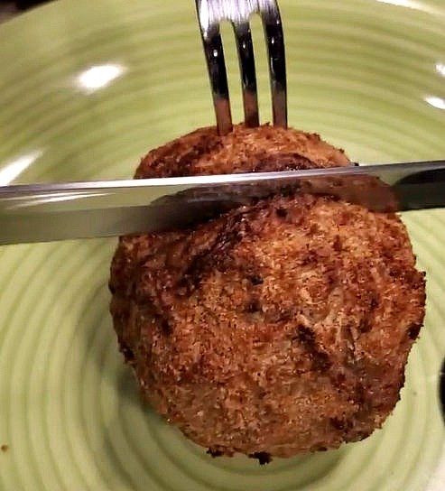 Slice cooked scotch egg in half