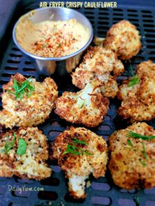 cauliflower florets with charred edges in air fryer basket