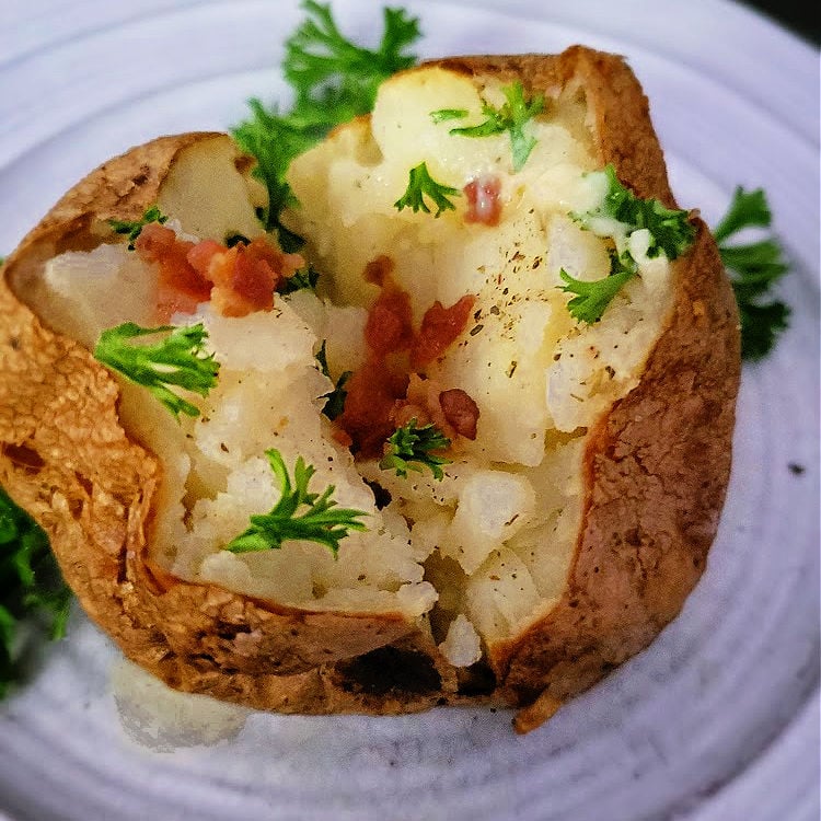 Golden, crispy-skinned air fryer baked potatoes with a fluffy interior, ready to be topped with your favorite toppings