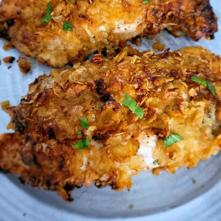 Golden, crispy air fryer cornflake chicken breast served on a plate