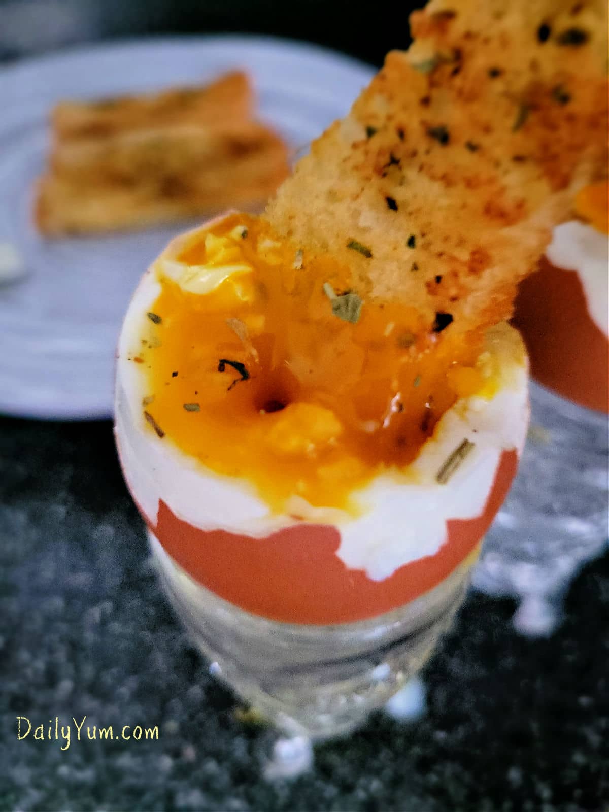 garlic toast soldier dipped into runny egg yolk