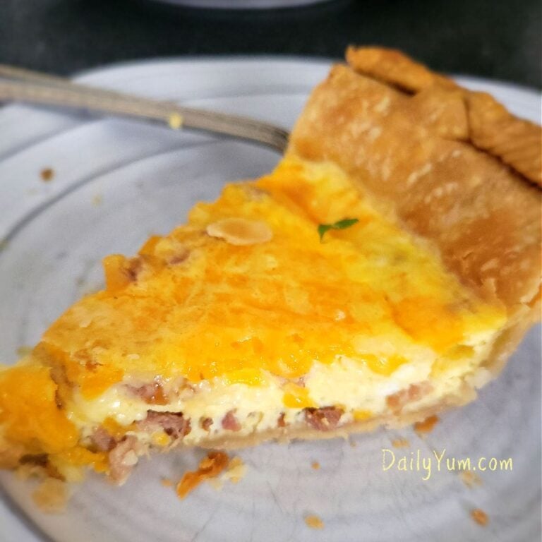 Close-up of a golden-brown bacon, egg, and cheese quiche with a flaky crust and a fluffy, cheesy interior, freshly baked in the air fryer
