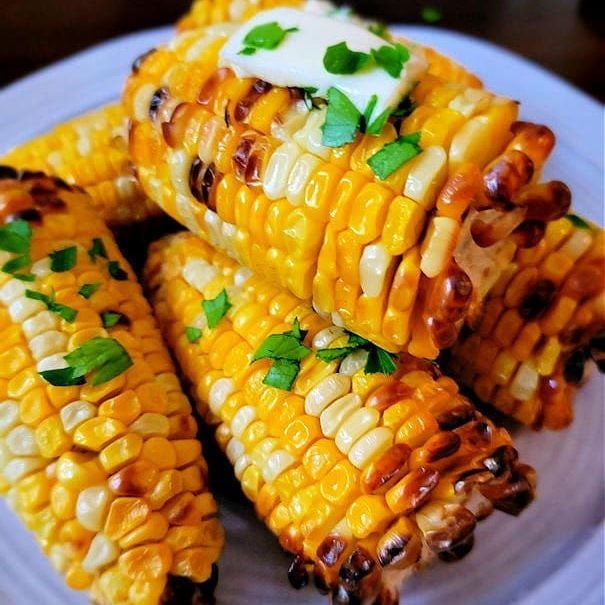 charred air-fried corn on the cob cut in half