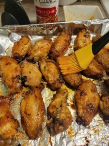 brushing wings with sweet chili sauce