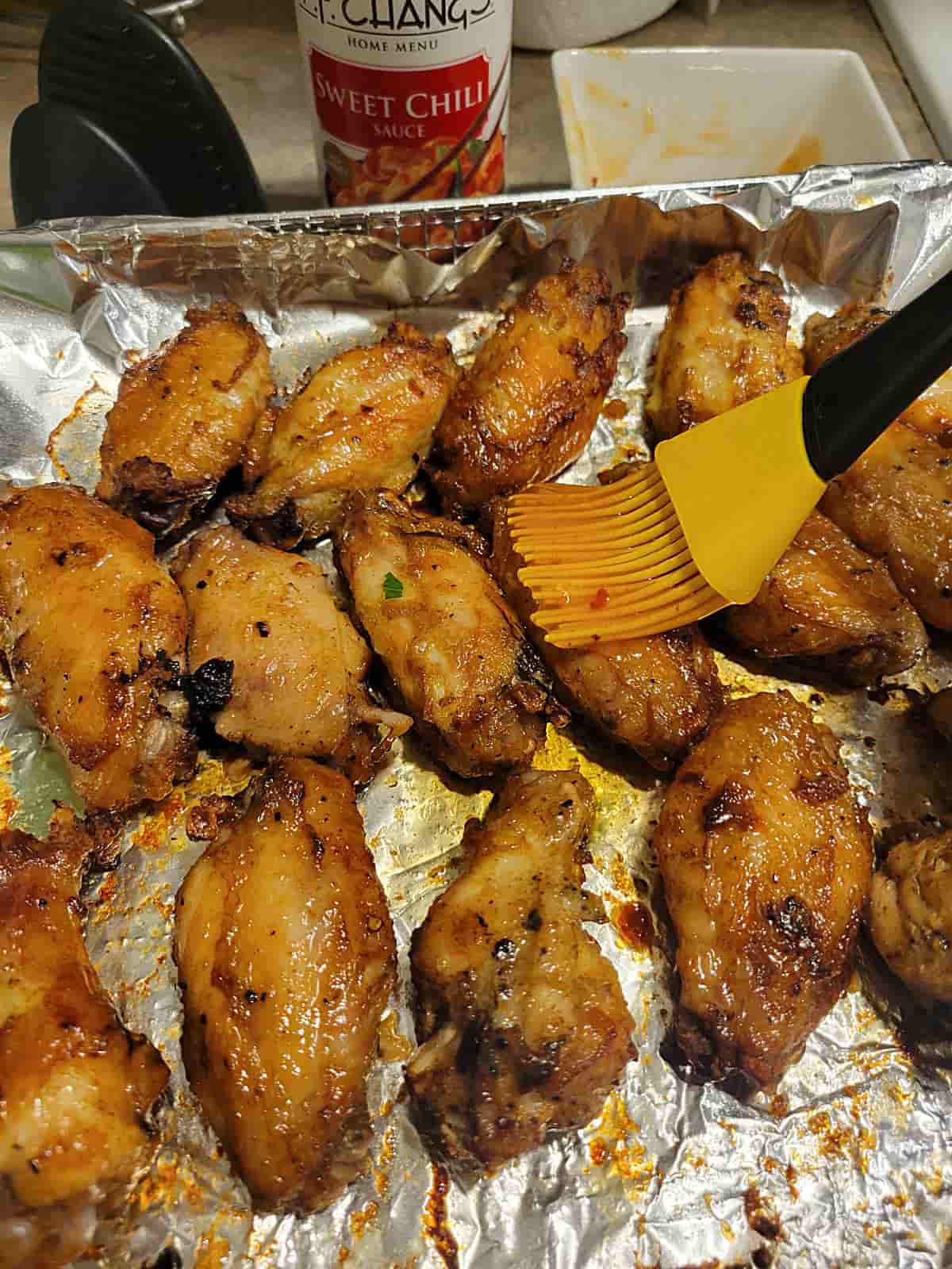 brushing wings with sweet chili sauce