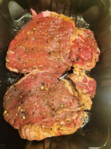 marinating filet mignon steak with salt, pepper, garlic powder and olive oil