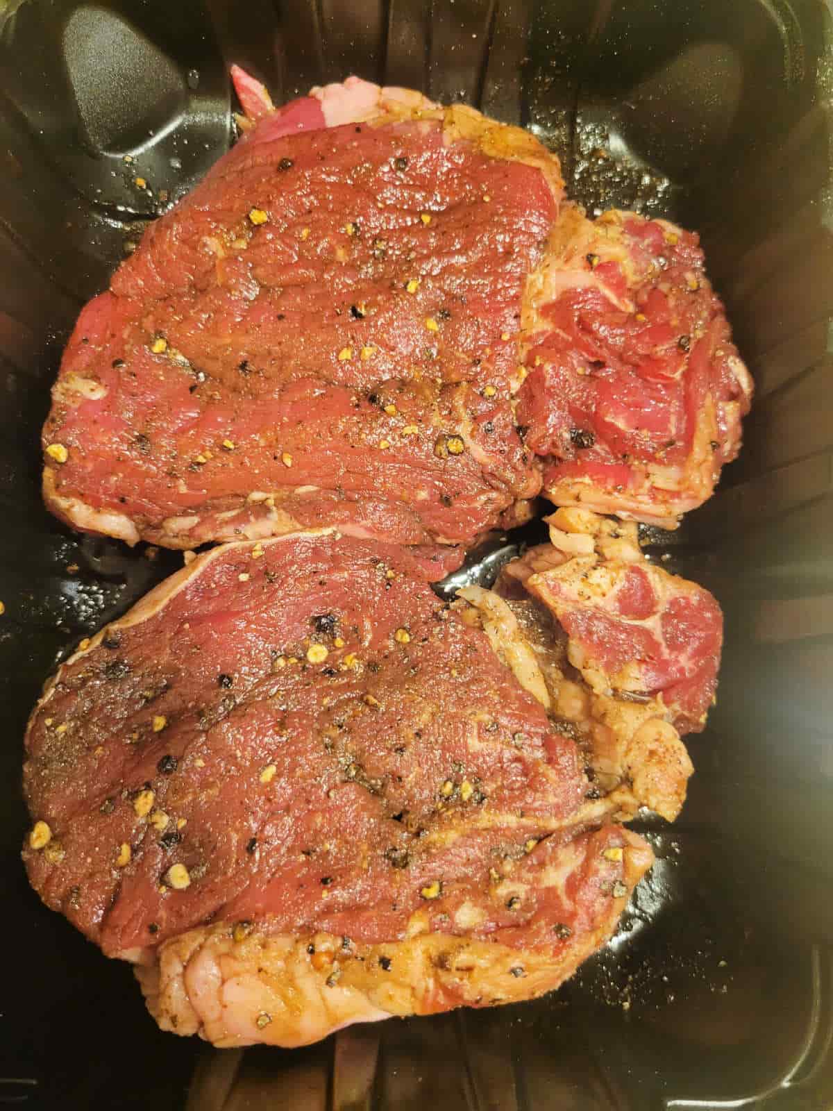 marinating filet mignon steak with salt, pepper, garlic powder and olive oil