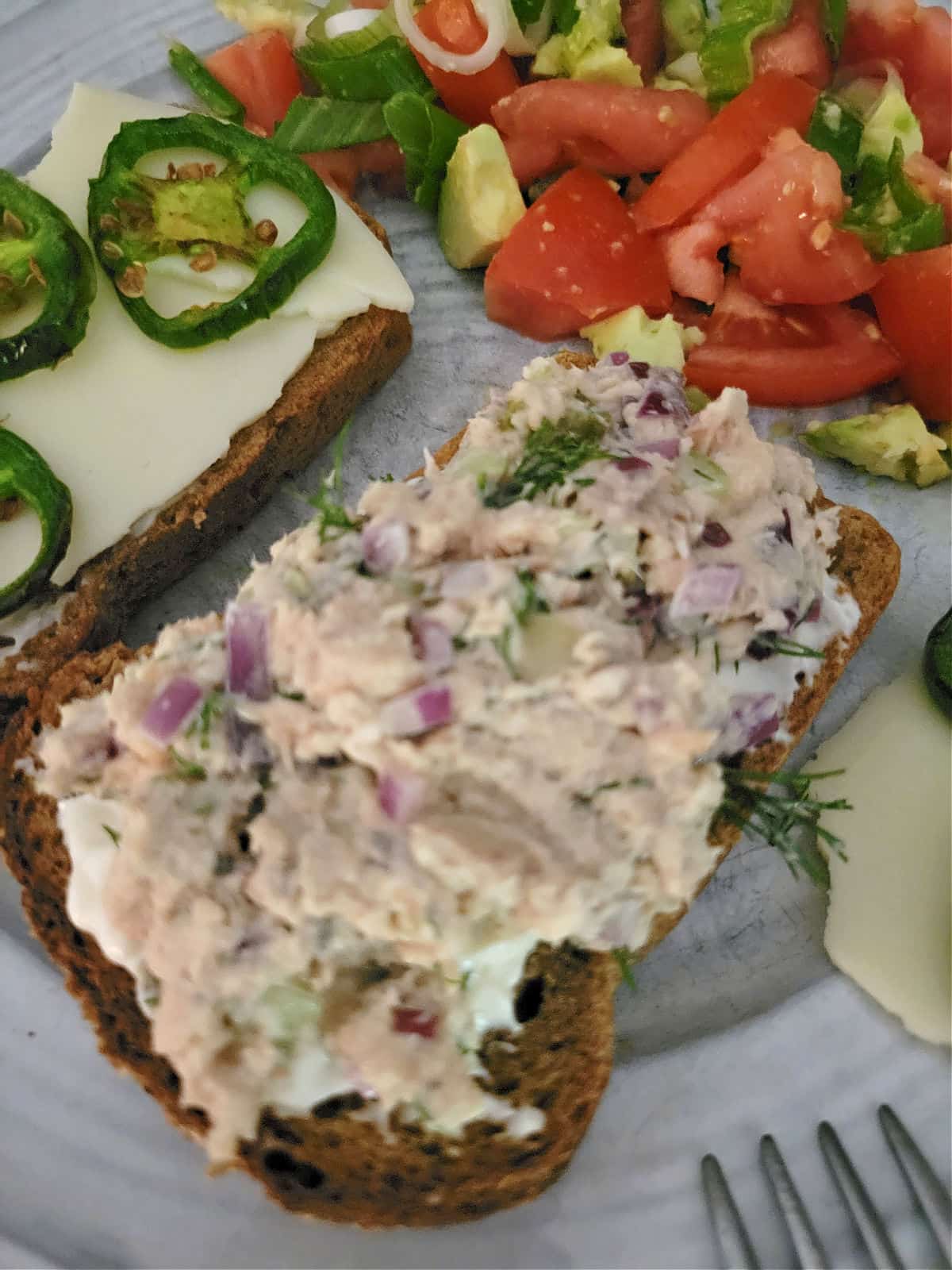 tuna salad with sliced jalapenos on top of bread