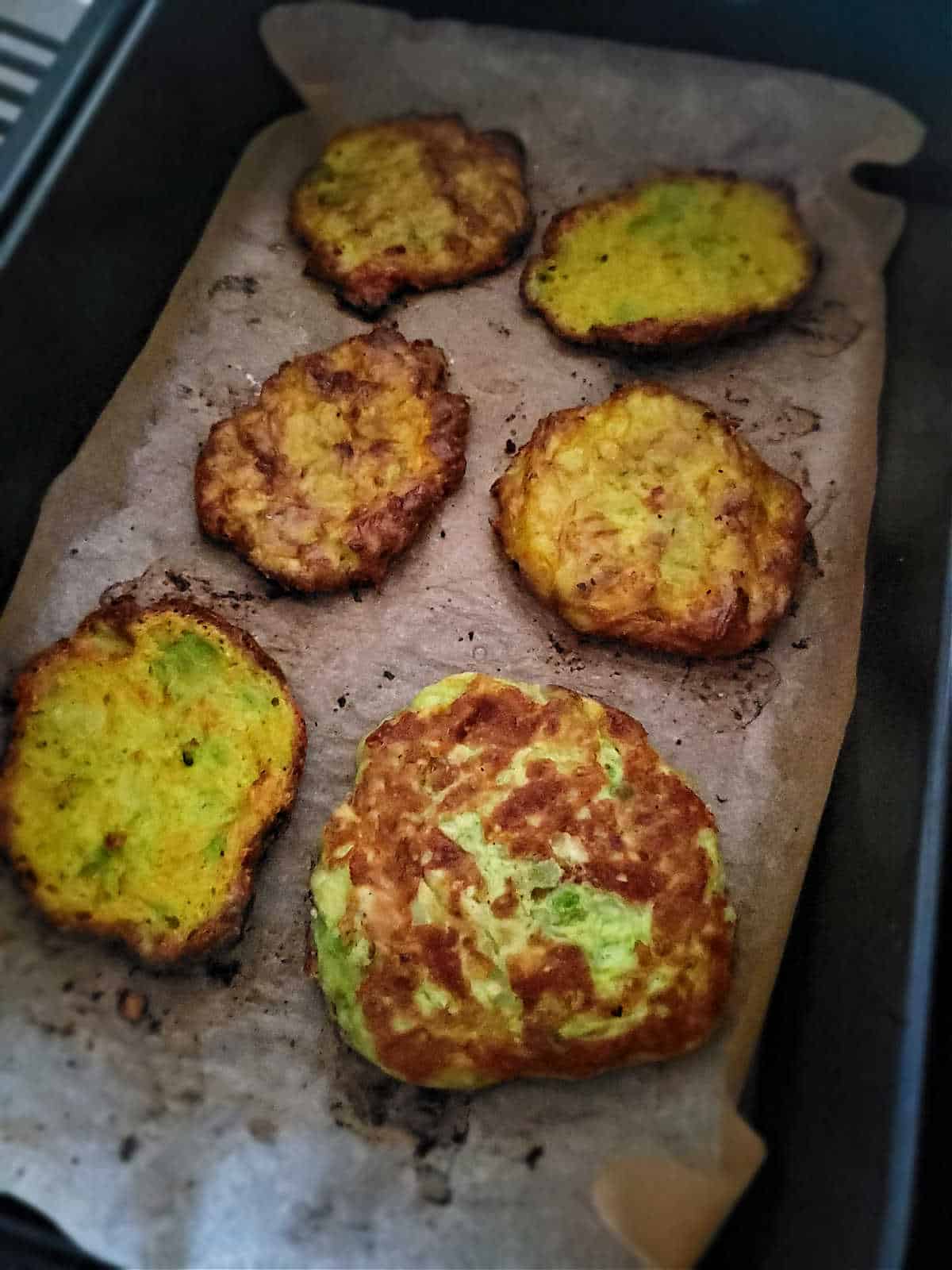 golden fritters on parchment paper in air fryer