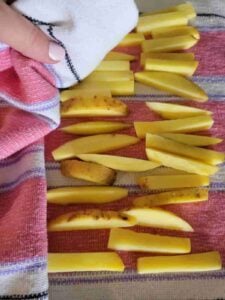 potato slices are on top of a dry kitchen towel