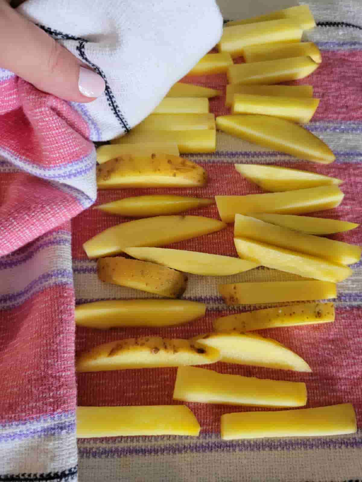 potato slices are on top of a dry kitchen towel