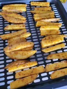 potato slices in a single layer of air fryer basket