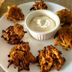 onion fritters on a plate with a dipping sauce