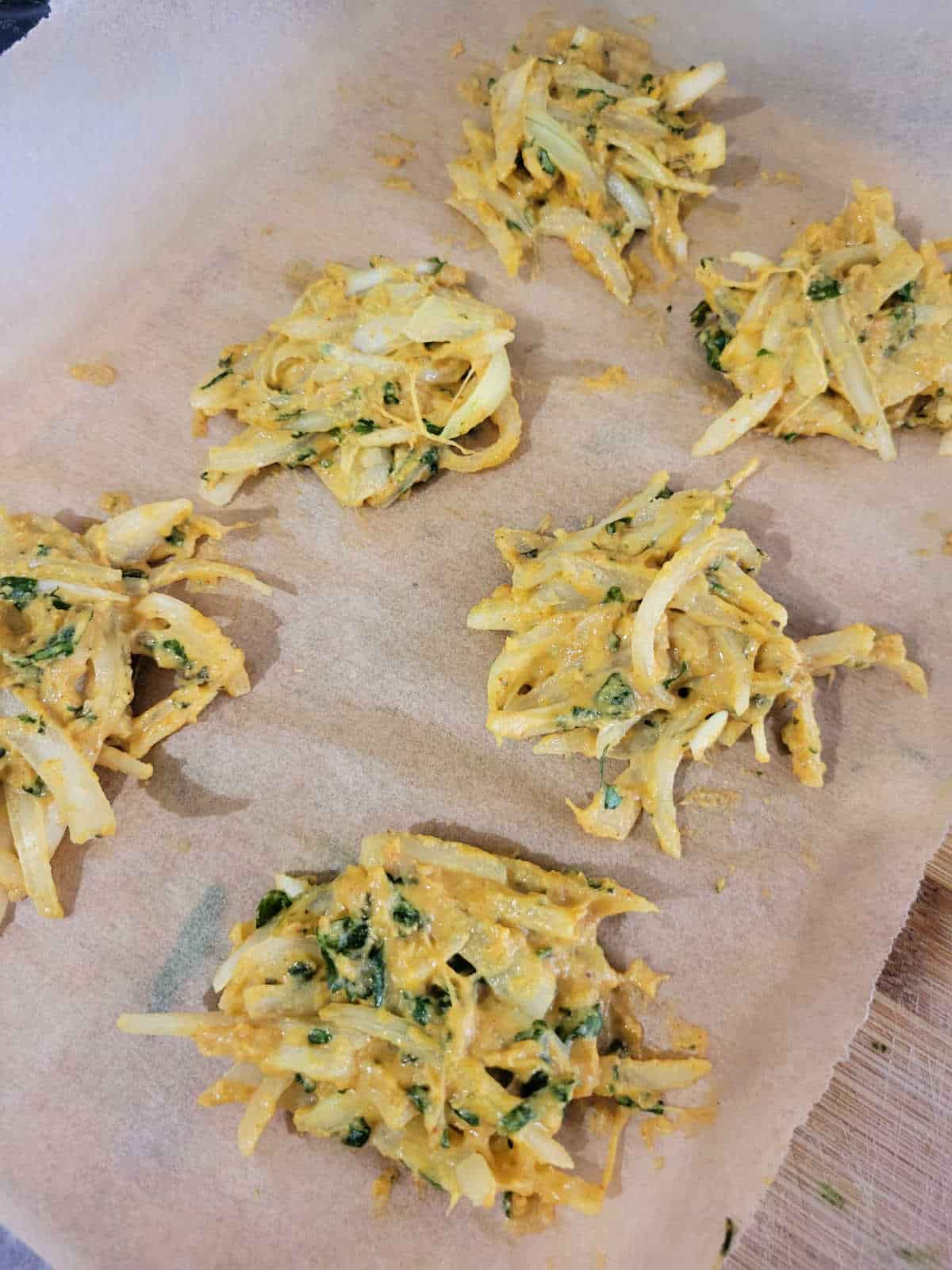 onion fritters on parchment paper