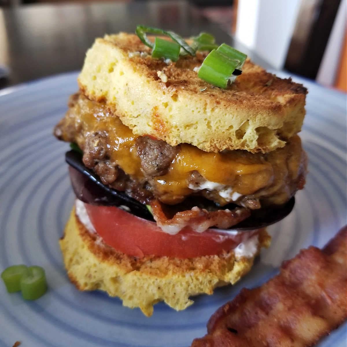 a juicy burger sandwiched between keto mug bread