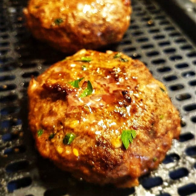 Golden, juicy air fryer cheeseburgers in air fryer basket